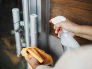 Person Cleaning Door Bar Handle