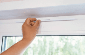 Person Installing Trickle Vent Above a Window